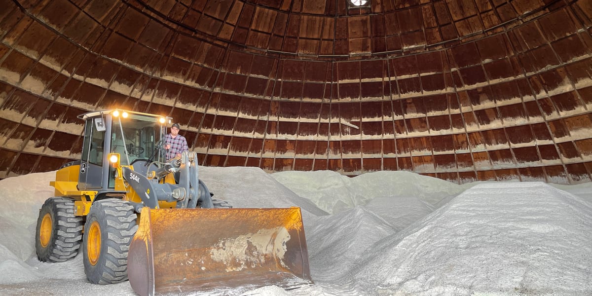 Wheel loader moving a pile of road salt inside a salt storage facility
